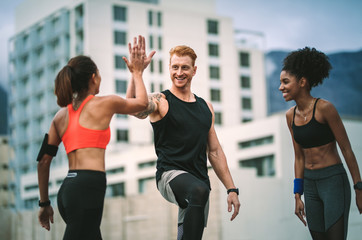 Fitness people relaxing after workout standing on rooftop