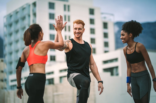 Fitness people relaxing after workout standing on rooftop