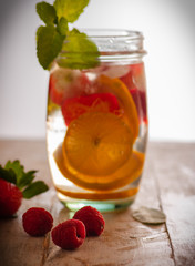 Fresh drink with strawberries, lemon and mint. Serving on a wooden table