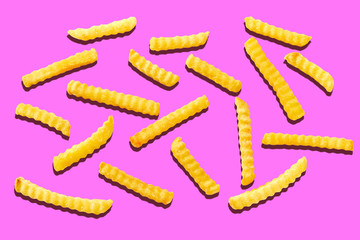 Fusilli pasta spread on pink background
