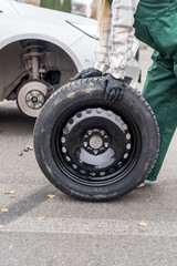 Spare wheel with worker's hands close up