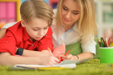 Fototapeta premium Close up view of smiling mother and son drawing with pencils