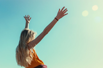 Teen girl stretches her arms to the sun. The concept of adolescent transition.