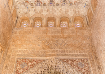 Fototapeta na wymiar Arch with arabesque caligraphy and Mocarabe honeycomb designs in Comares Palace of Nasrid Alhambra Granada, Andalusia