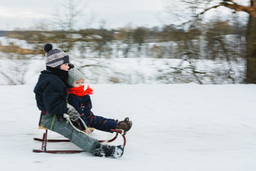 Fototapeta na wymiar Small boy sledding at winter time. Motion blur