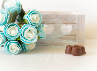 blue roses and chocolates detail with wooden box background