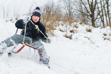 the child tries to stay in the sled so as not to fal