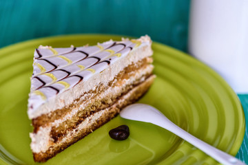 Biscuit cake on a wooden background photographed on a ceramic plate in green.