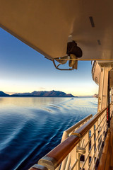 Beautiful golden early morning light of dawn and ocean water ripples from ship's wake, Inside Passage, Alaska, USA.