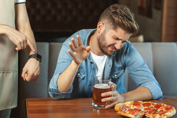 waiter showing time of closing cafe to customer