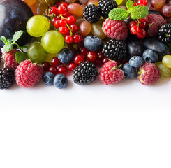 Mix berries on a white background. Ripe red currants, grapes, blackberries, blueberries and raspberries on white background. Top view. Fruits with copy space for text. Black-blue and red food.