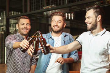 men clicking with beer bottles