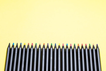 Color pencils on a yellow background close-up