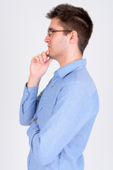 Profile view of young handsome businessman with eyeglasses thinking