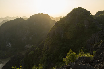 Fototapeta na wymiar Amazing panorama view of limestone rocks and mountaintops from Hang Mua Temple at evening. Ninh Binh, Vietnam. Travel landscapes and destinations background