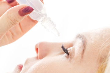 Close up of female face and eye drops