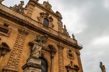 Baroque Church of San Pietro in Modica, exterior detail with statue of saint, Sicily, Italy.
