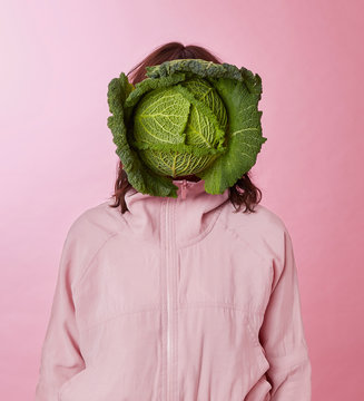 Woman's face covered with cabbage