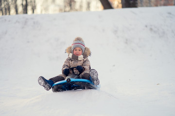 Fototapeta na wymiar boy sledding down the hill in the park
