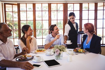 Waitress serving coffee on the table