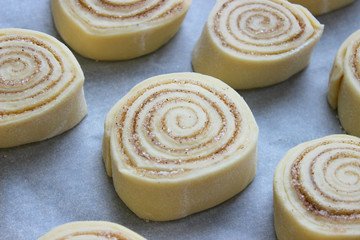 Beautiful fresh cinnamon rolls. The cooking process. Fresh fragrant pastries. Raw dough for buns.Close up.