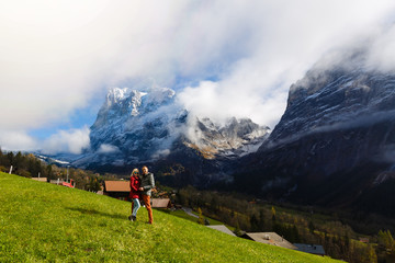 Fototapeta na wymiar Young couple of travelers enjoying a mountains view, Grindelwald Switzerland