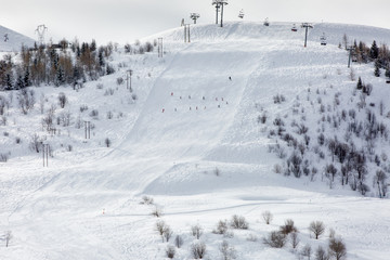 Obraz premium Slope of the Alps in France with a group of school mountain-skiers