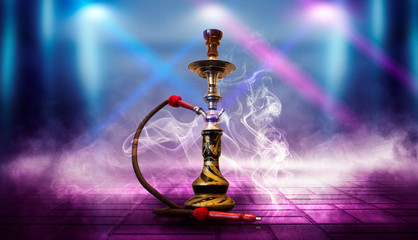 Smoking hookah on a blue futuristic background with pink neon rays, smoke, spotlight