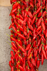 Bunches of red pepper hand on stones wall