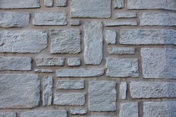 fragment of old stones wall of village building.