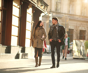 Dreamy couple carefree walking on street of old city at sunset
