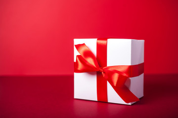 Gift box on red background. Valentine day, woman day gift. Red and white. ribbon, band.