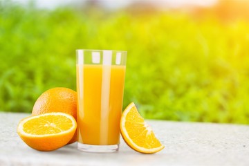 Glass of orange juice on a white background and oranges