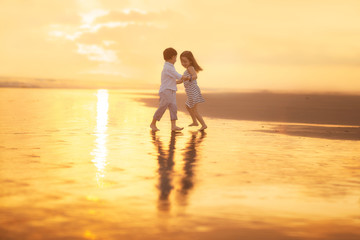 Fototapeta na wymiar girl and boy dancing on the beach