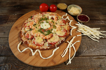 Seafood pizza, shrimp and mozzarella cheese on a wooden rustic table 