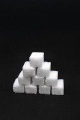 Tower built out of sugar white cubes on an isolated black background with blank space