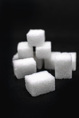 Tower built out of sugar white cubes on an isolated black background with blank space
