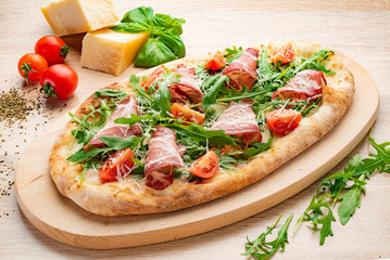 pizza with bacon and cherry tomatoes on the wood board