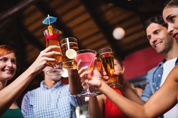 Friends toasting drink glasses in nightclub