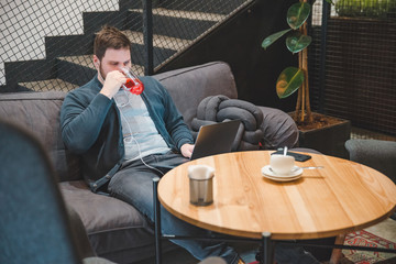man sitting in cafe with headset and laptop. working in cafe. freelance concept