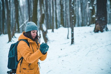 Fototapeta na wymiar woman making snowball in snowed forest