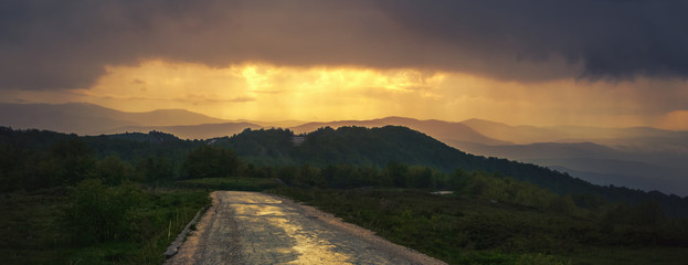 Lonely road in mountain. Panoramic view of mountain layers in sunset.