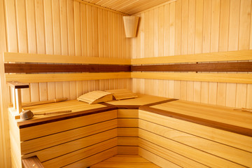 Fototapeta na wymiar Traditional wooden sauna. Classic interior. Empty seats, bucket lies.