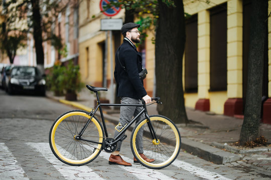 People, style, city life and lifestyle. Young hipster bearded man with shoulder bag and fixed gear bike crossing crosswalk on street