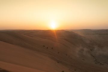 Fototapeta premium sun setting behind dunes