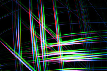 A colorful and glowing light painting abstract image with red, green, blue and yellow blurry lines over a black background, creating a net