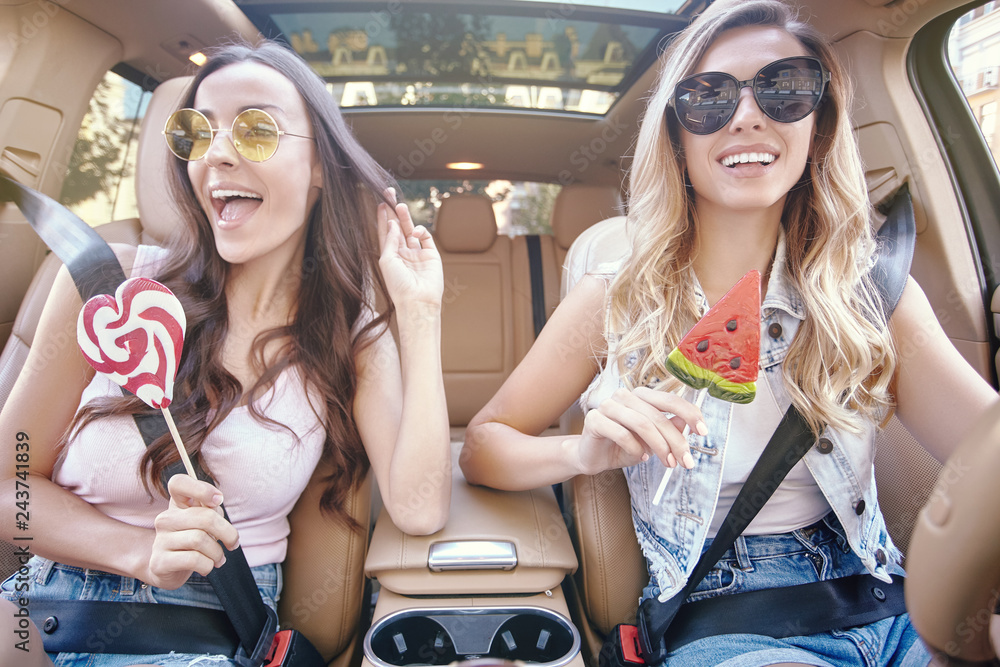 Poster women wearing sunglasses holding big lollipops