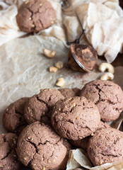 Chocolate cookies with nuts on a brown wooden tray. A old brown concrete background. Copy space for text.