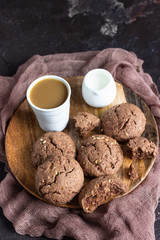 Delicious chocolate cookies with nuts on dark old concrete table. Copy space.