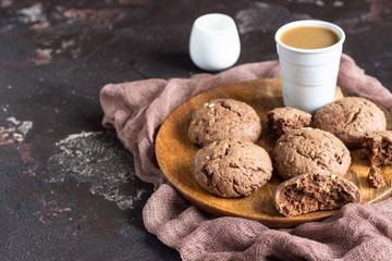 Delicious chocolate cookies with nuts on dark old concrete table. Copy space.
